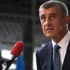 Andrej Babiš stojí u mikrofonu.
