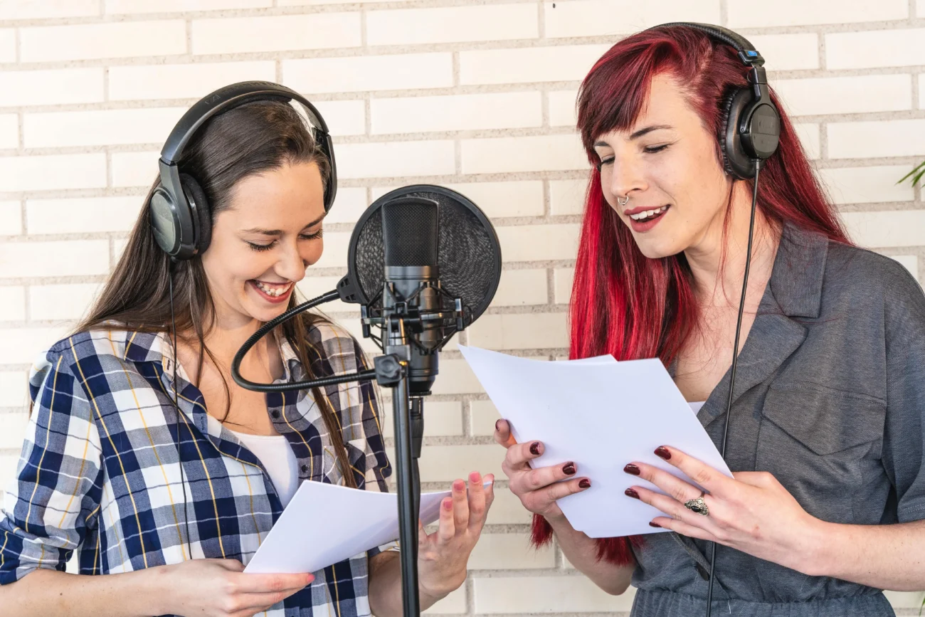 shutterstock_1942270207-min | TVGURU.cz dvě ženy se sluchátky čtou papír