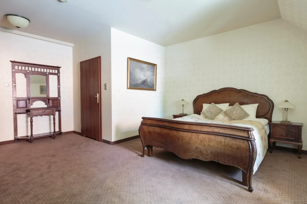 ložnice s ebenovou postelí, která stojí u stěny