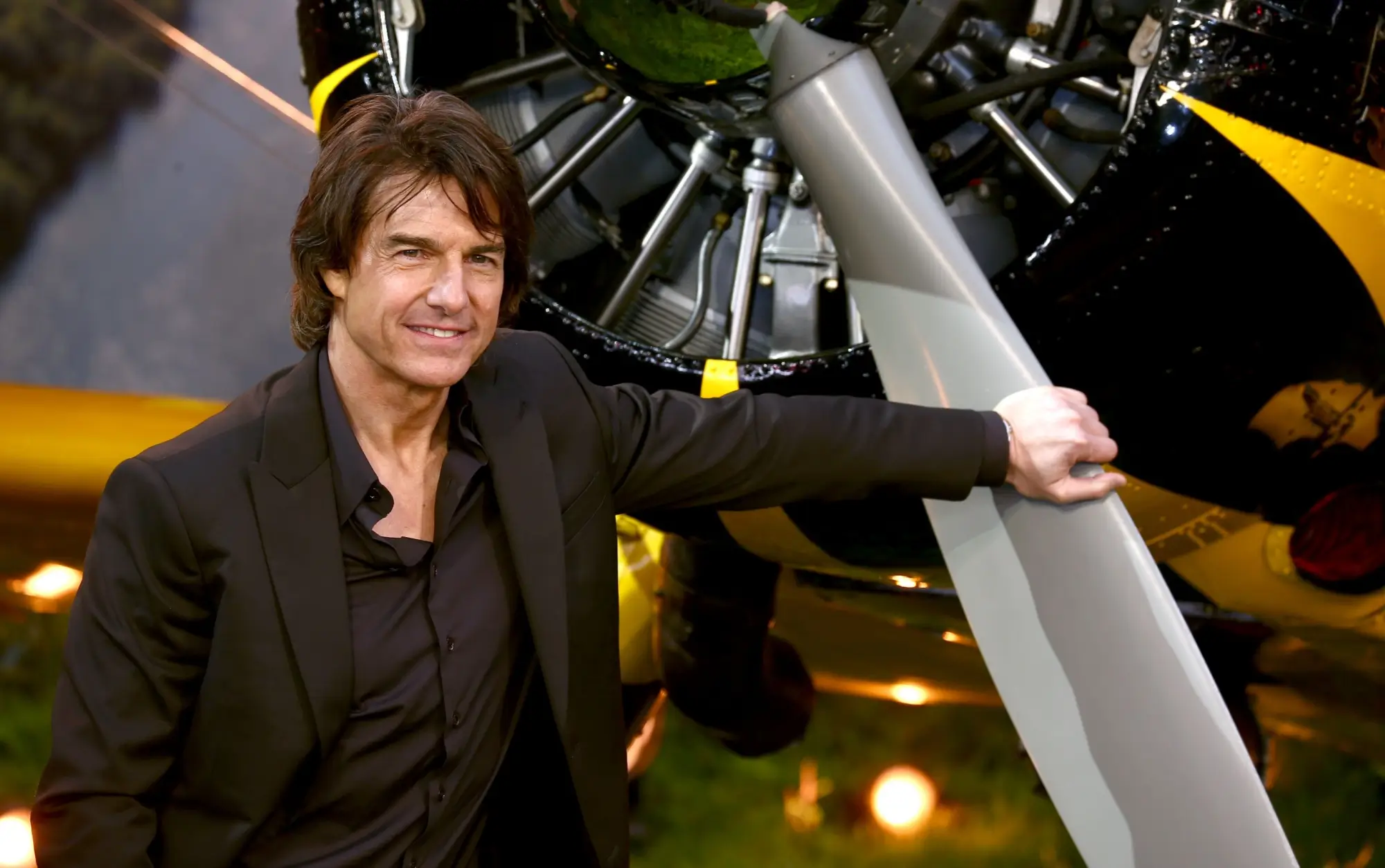 Shutterstock_2633405881 | TVGURU.cz Tom Cruise se opírá o vrtuli letadla