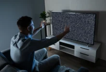 Muž sedí před zčernalou obrazovkou.