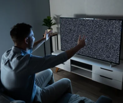 Muž sedí před zčernalou obrazovkou.