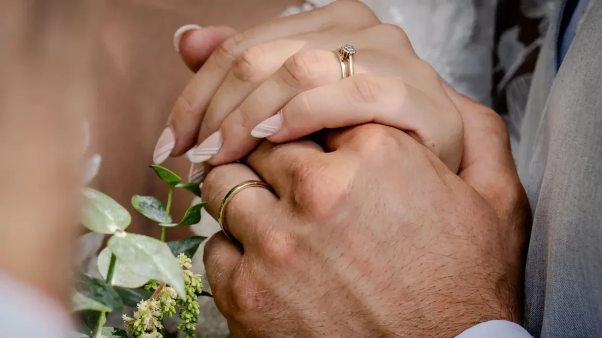 Tihle dva by mohli sloužit jako vzor pro vysněný vztah. dva lidé se láskyplně drží za ruce na svatbě