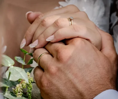 Tihle dva by mohli sloužit jako vzor pro vysněný vztah. dva lidé se láskyplně drží za ruce na svatbě