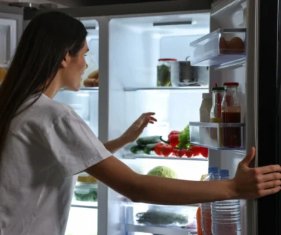 shutterstock_2441300303 1 Žena kouká do otevřené lednice.