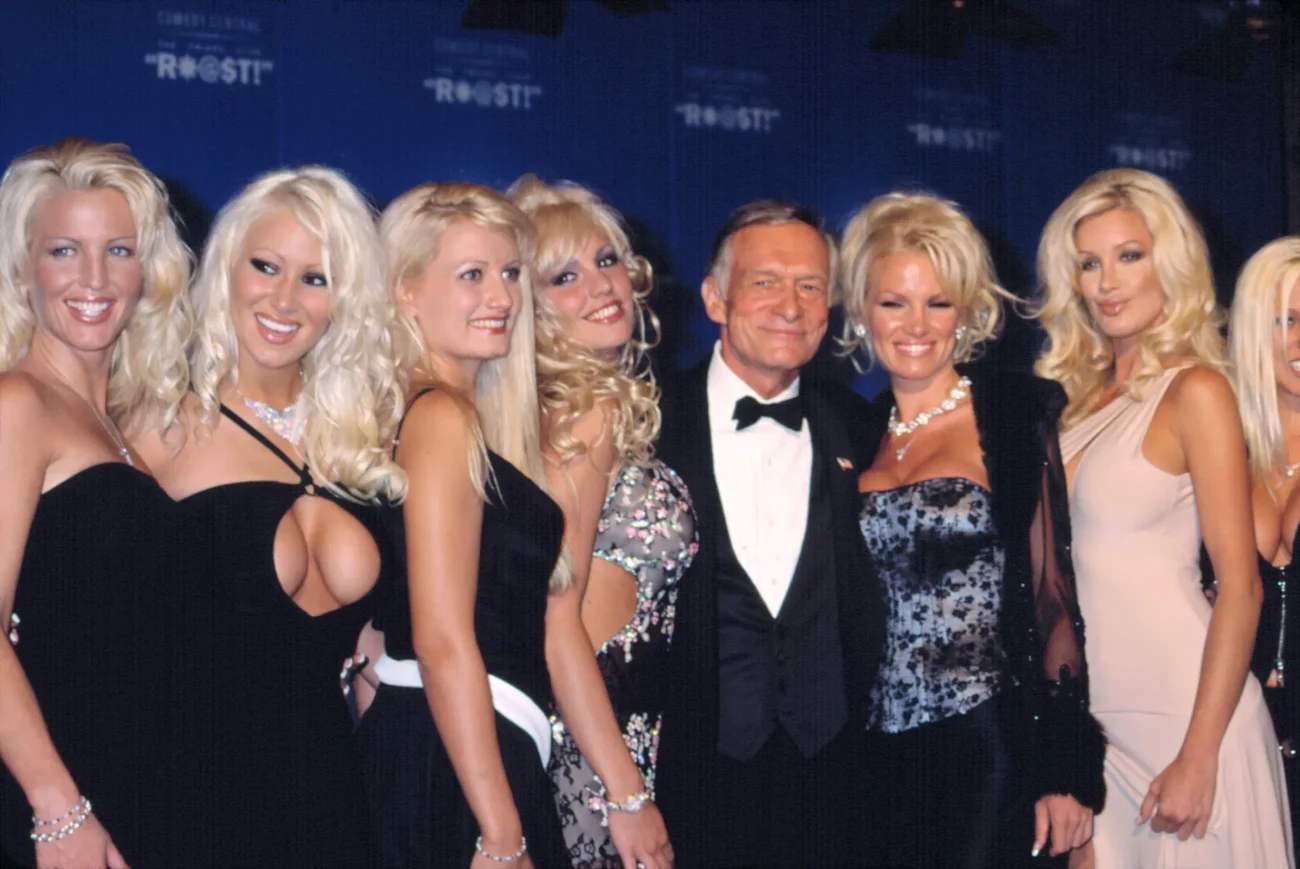 Hugh Hefner stojí mezi ženami. 