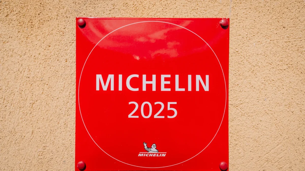 Klasické červené označení "michelinské restaurace" (2025) na zdi budovy
