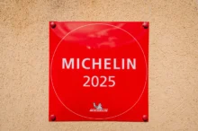 Klasické červené označení "michelinské restaurace" (2025) na zdi budovy