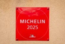 Klasické červené označení "michelinské restaurace" (2025) na zdi budovy