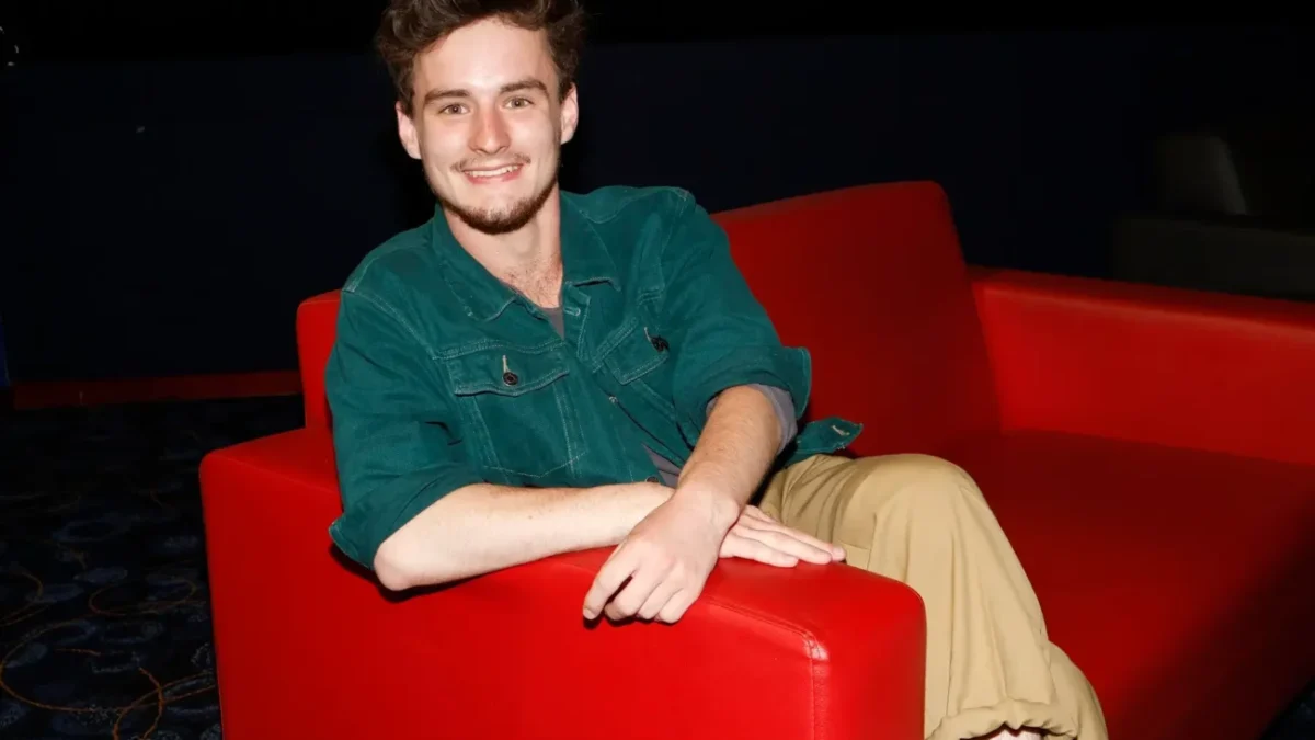 ondřej stupka sedí v červeném křesle a usmívá se