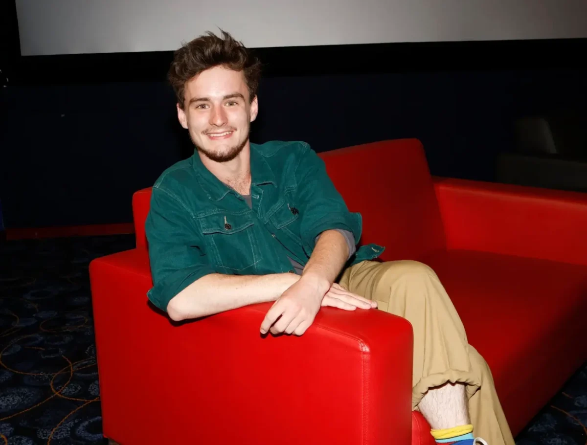 ondřej stupka sedí v červeném křesle a usmívá se