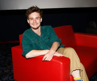 ondřej stupka sedí v červeném křesle a usmívá se