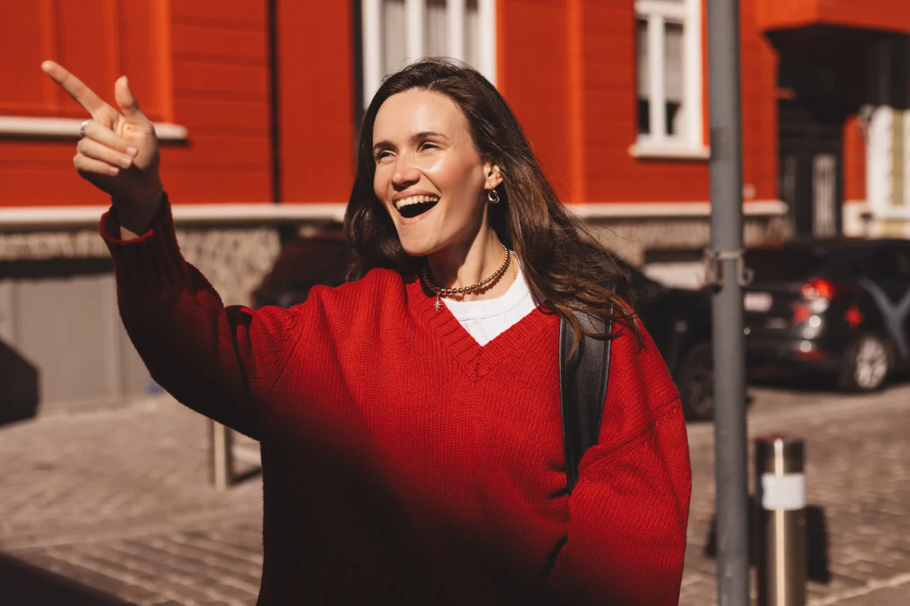 Žena stojí venku a ukazuje. 