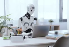 Robot něco píše do notebooku.