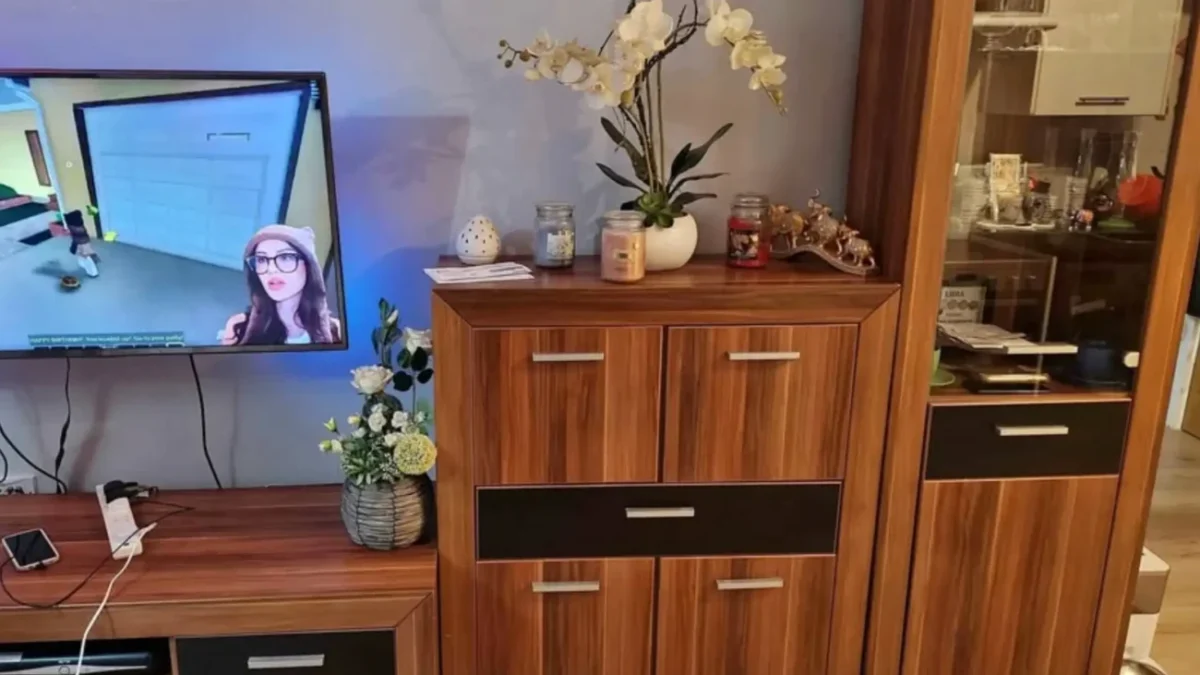 televizní stěna v obýváku doma se zapnutou televizí