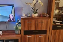 televizní stěna v obýváku doma se zapnutou televizí