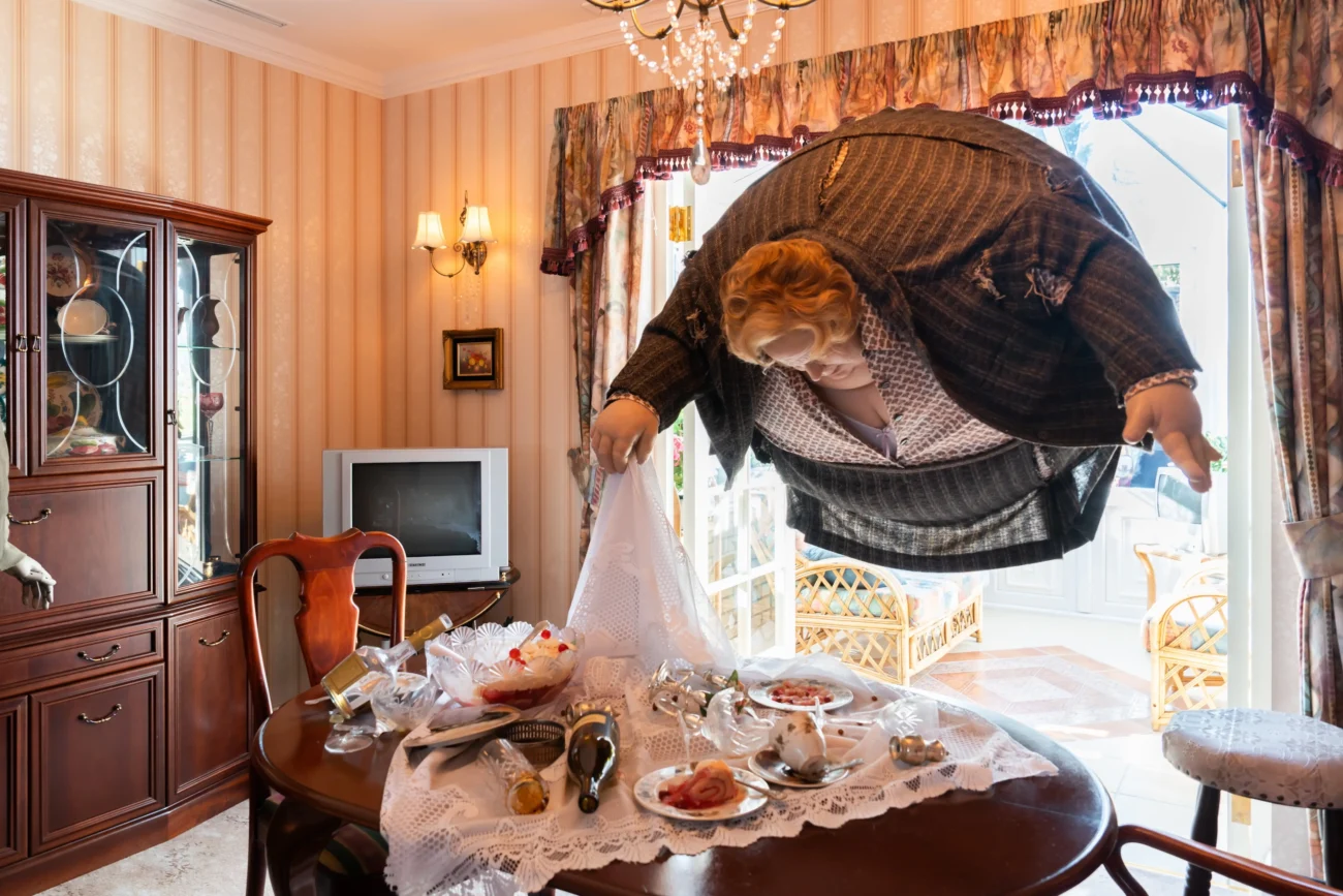 Nafouklá figurína létá nad stolem. 