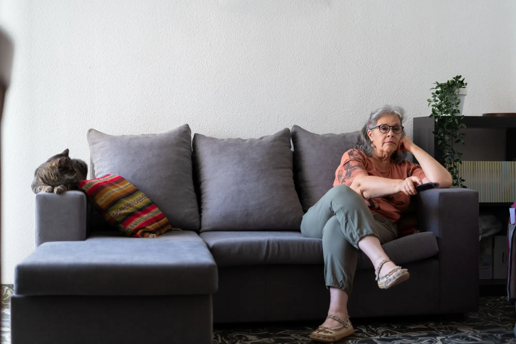 unavená seniorka sedí na gauči