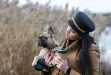 Žena v ruce drží kávu a pejska.