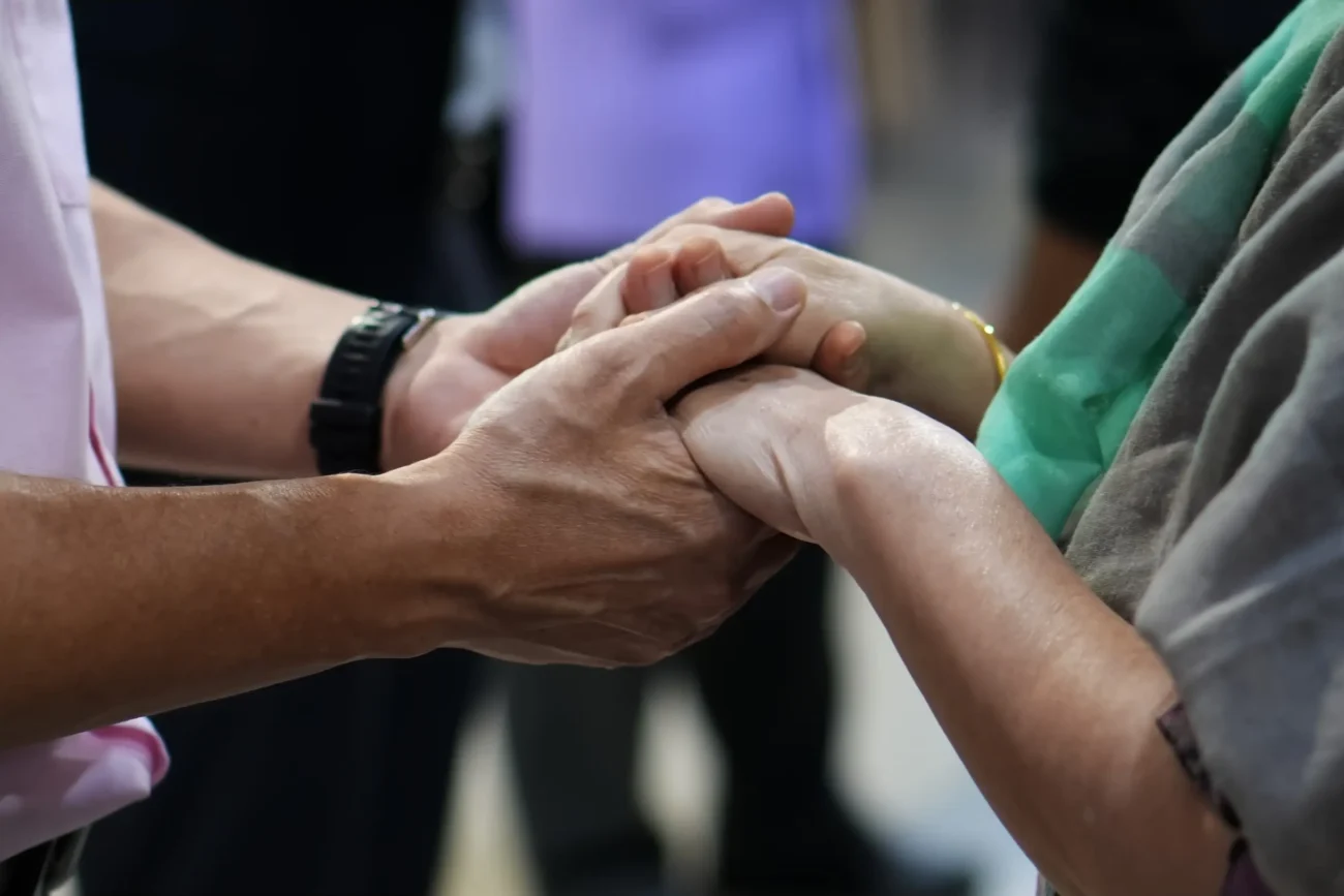 Lidé se drží za ruce.