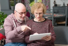 Starší lidé čtou něco z papíru.