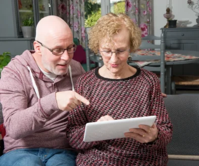 Starší lidé čtou něco z papíru.