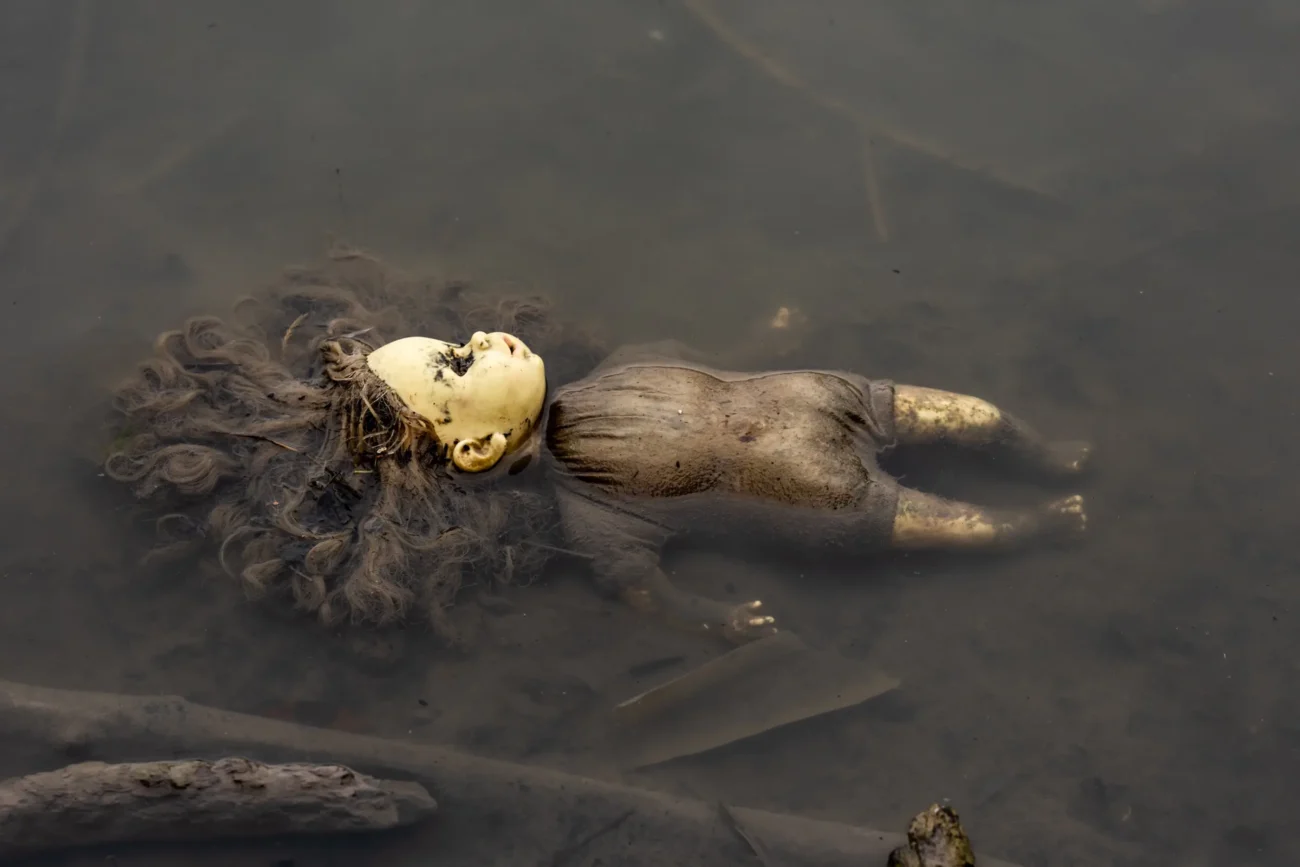 Panenka se válí ve špinavé vodě.