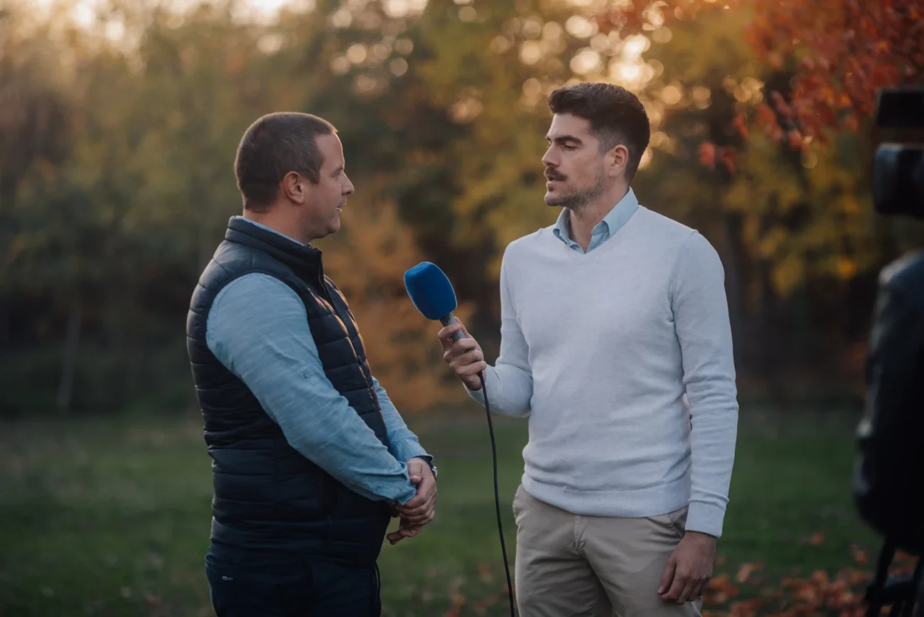 Dva muži dělají rozhovor s mikrofonem. 