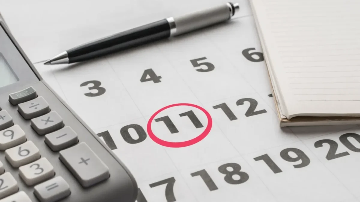 kalendář se zakroužkovanou 11, vedle propiska a kalkulačka