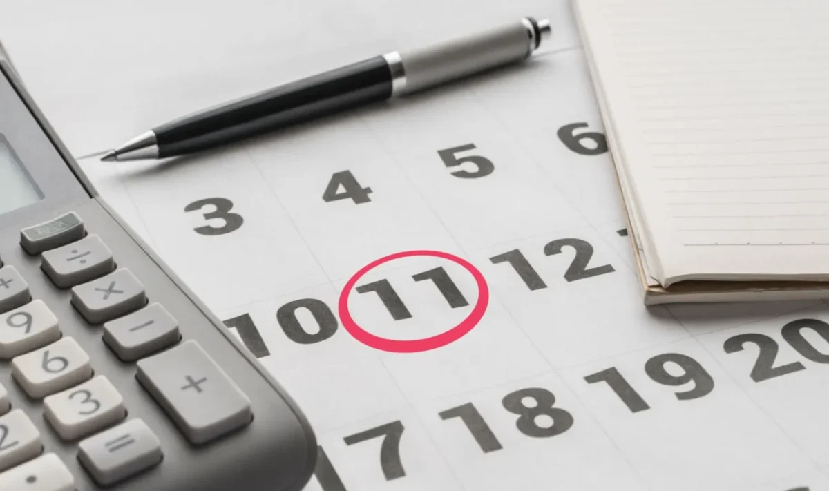 kalendář se zakroužkovanou 11, vedle propiska a kalkulačka