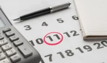 kalendář se zakroužkovanou 11, vedle propiska a kalkulačka