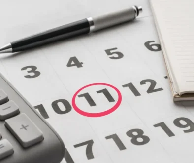 kalendář se zakroužkovanou 11, vedle propiska a kalkulačka