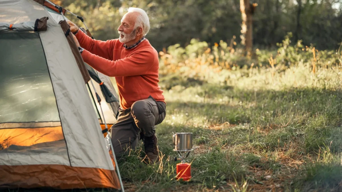 Starší muž staví stan.