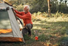 Starší muž staví stan.