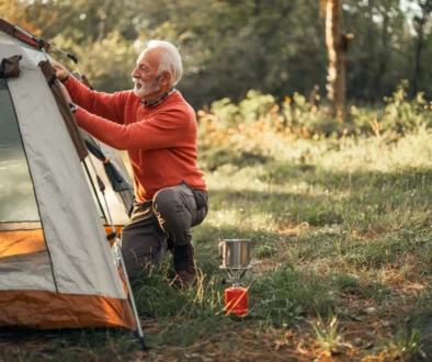 Starší muž staví stan.