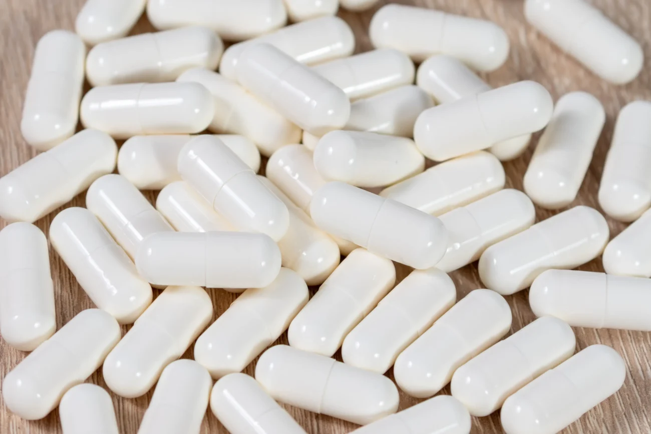 shutterstock_1218914506-2 | TVGURU.cz Na stole leží bílé pilulky.