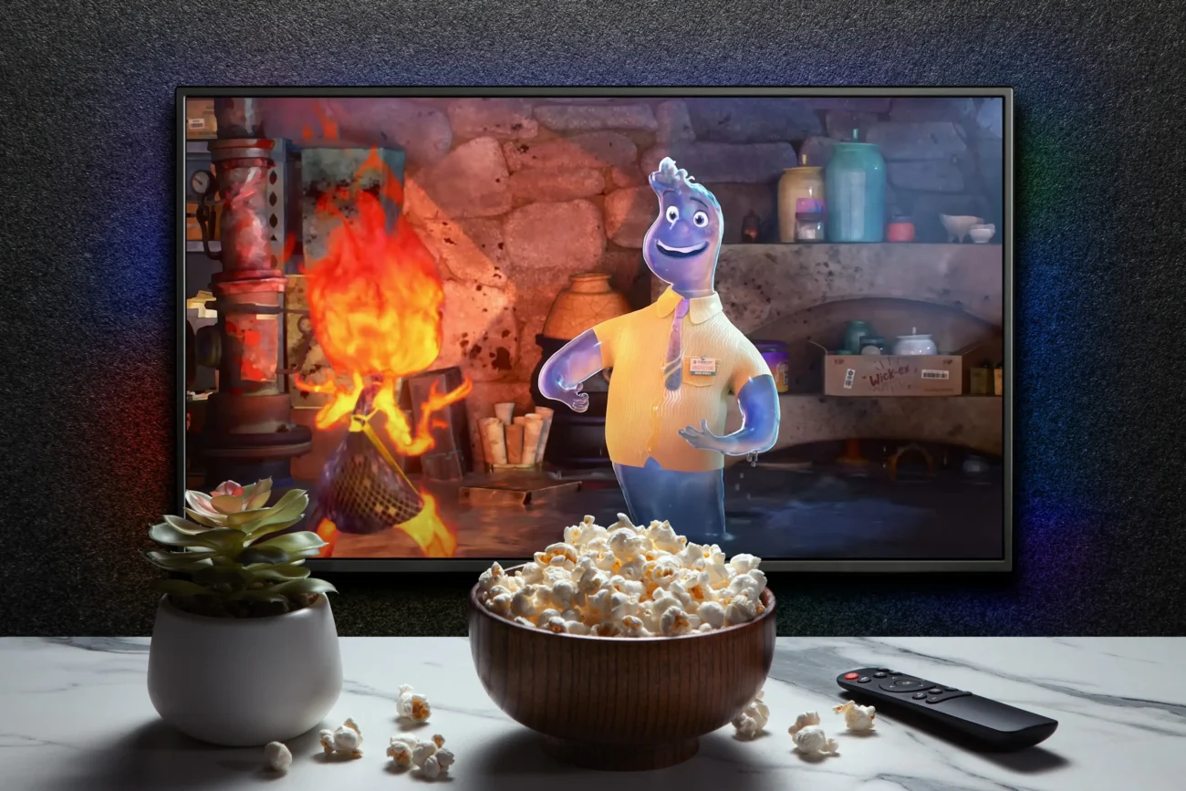 Animovaný film na televizi s popcornem na stole. 