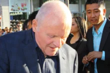 Anthony Hopkins stojí se skloněnou hlavou.