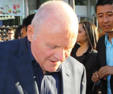 Anthony Hopkins stojí se skloněnou hlavou.