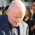 Anthony Hopkins stojí se skloněnou hlavou.