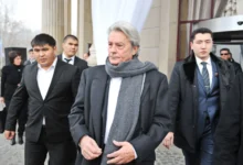 Alain Delon jde po ulici v obklopení ochranky.