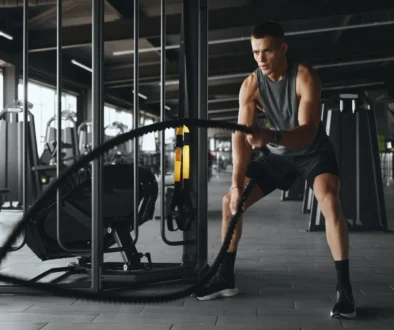 Muž cvičí s posilovacím lanem.