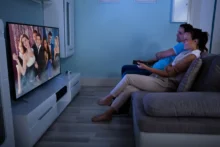 lidé se dívají na televizi z gauče