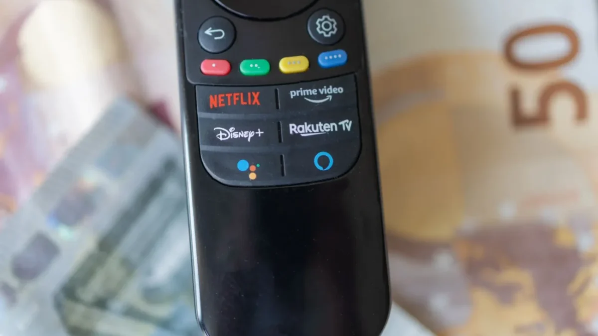 ovladač ležící na penězích, s tlačítkem Rakuten TV