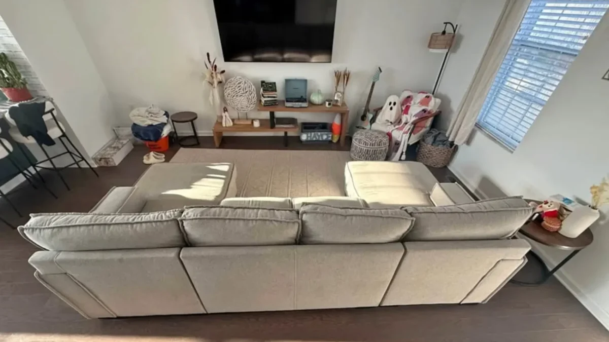 obývací pokoj s gaučem a televizí na stěně