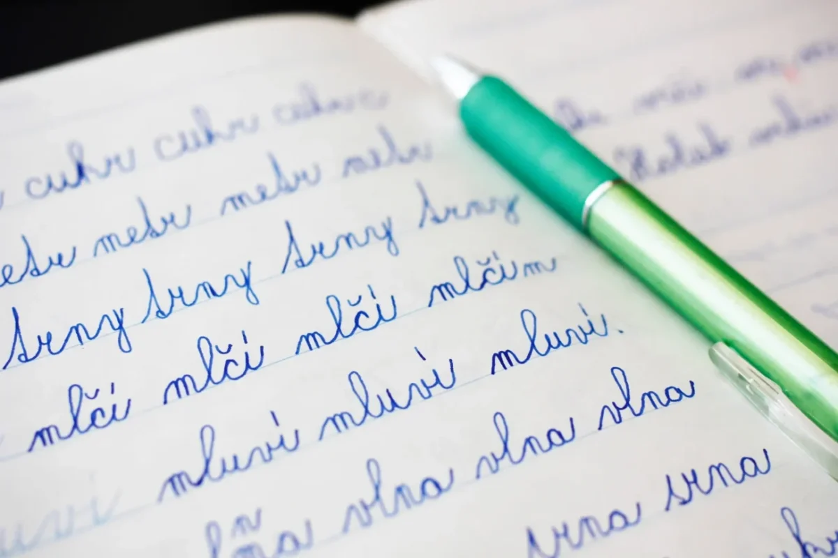 popsaný sešit s tužkou