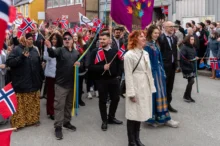 Norové stojí za sebou s vlajkami.