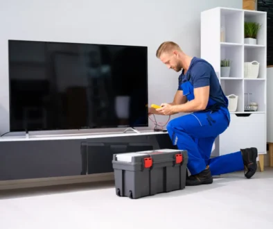 Technik klečí u televize.