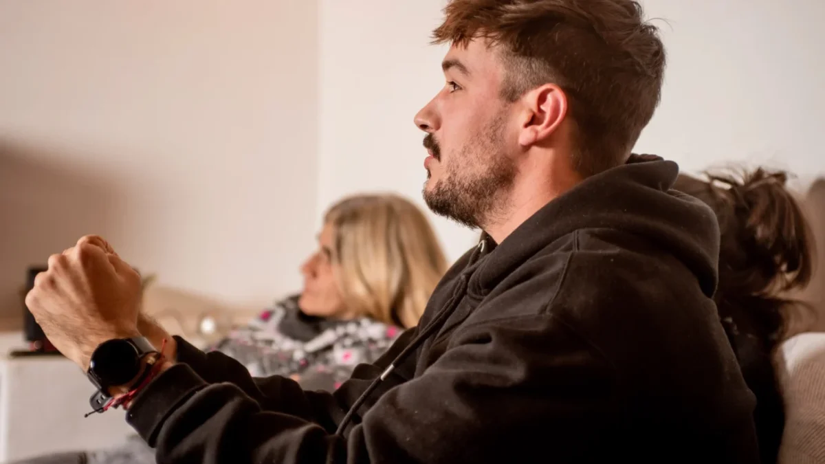 Mladý muž se dívá na televizi.