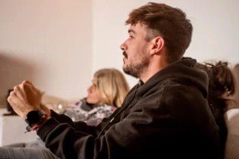 Mladý muž se dívá na televizi.